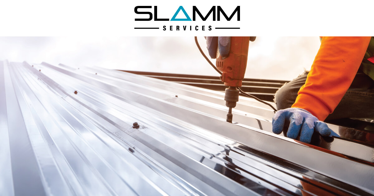 Worker using a power tool on a metal roof, representing Slamm Services' expertise in high-quality civil and construction solutions.